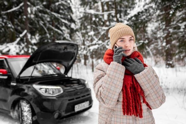 Woman by car talking on mobile