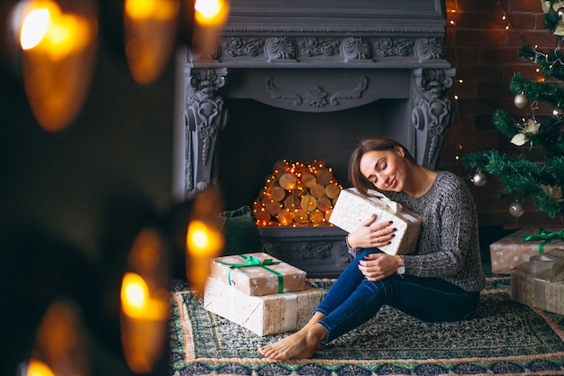 Free Photo woman by christmas tree unpacking presents