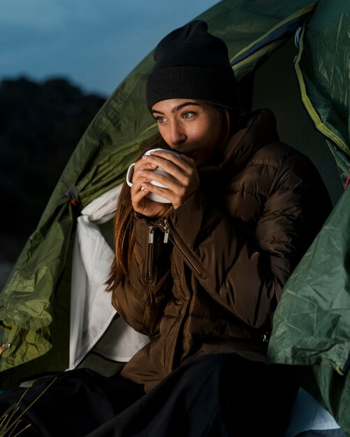 Woman camping and drinking a cup of tea