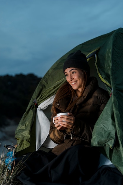 Free photo woman camping and holding a cup of tea