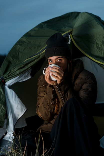 Free photo woman camping in the night with a cup of tea