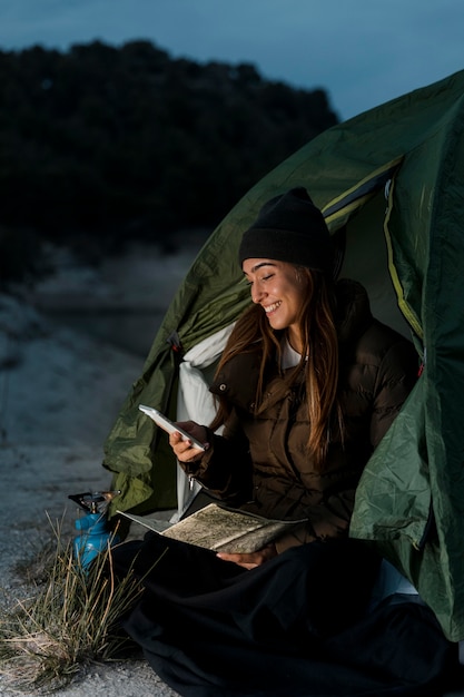 Woman camping and using mobile phone