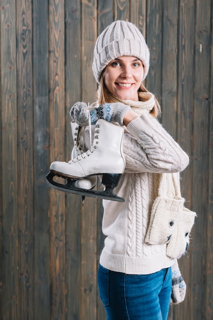 Free Photo woman in cap with skates behind back