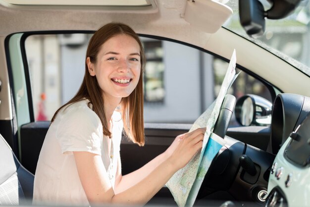 Woman in the car holding map for voyage