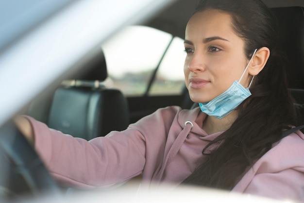 Free photo woman in the car do not use properly the mask