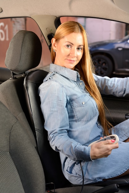 Free photo woman in car with massage seat cushion