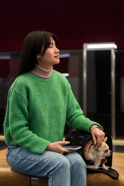 Free photo woman carrying her pet in the subway