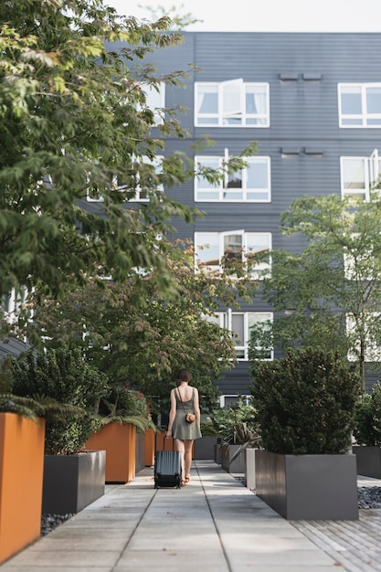 Woman carrying a luggage in the urban park