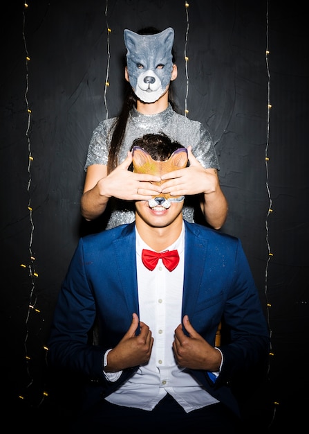 Free photo woman in cat mask closing eyes to man in fox mask