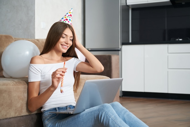 Woman celebrating birthday alone at home through video call