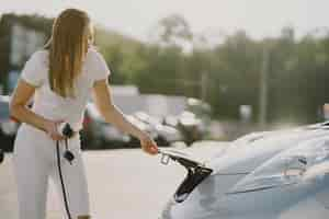 Free photo woman charging electro car at the electric gas station