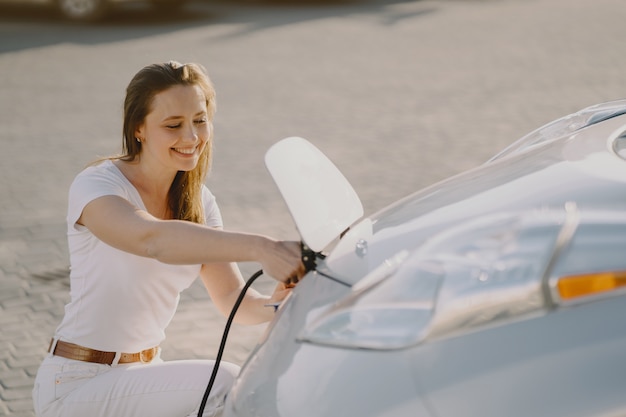 Free photo woman charging electro car at the electric gas station