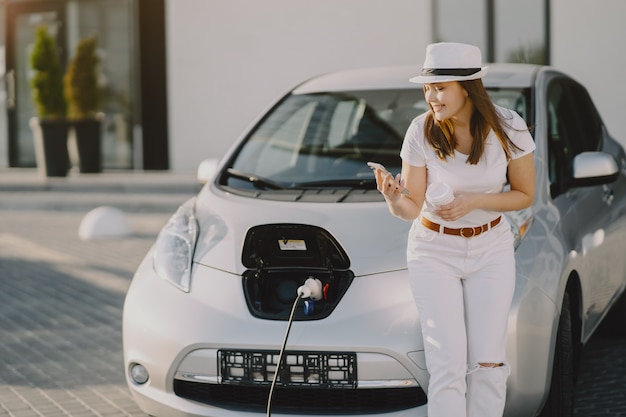 Free photo woman charging electro car at the electric gas station