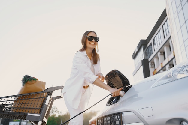 Free photo woman charging electro car at the electric gas station