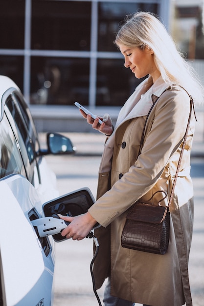 Free photo woman charging electro car at the electric gas station