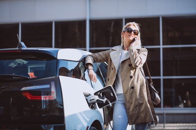 Free photo woman charging electro car at the electric gas station