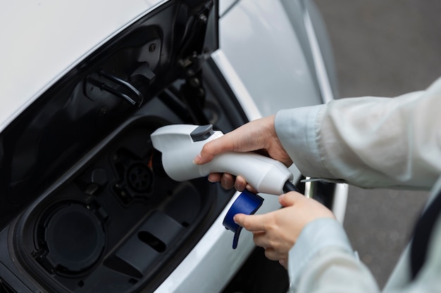 Woman charging her electric car at the station