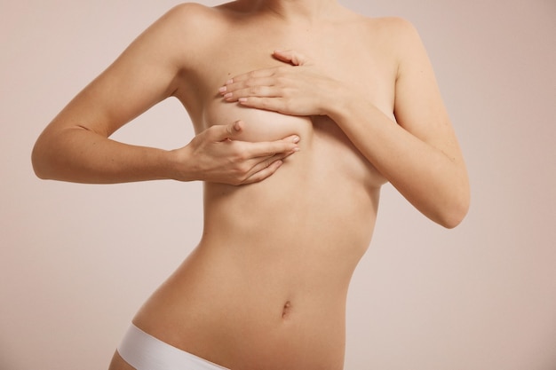 Woman checking her breast for breast cancer