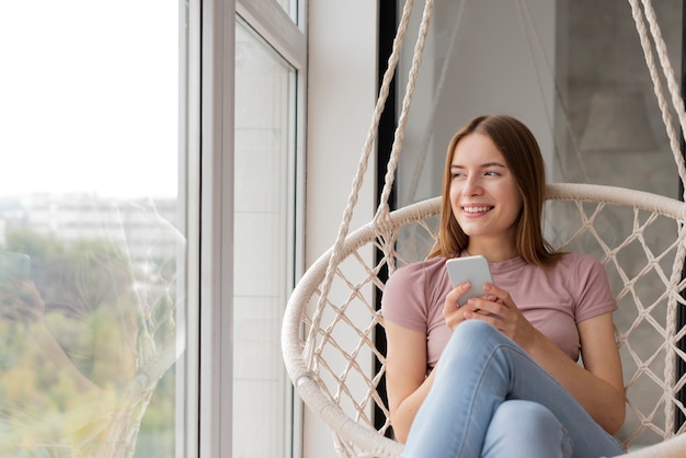 Woman checking her phone and looking on the window