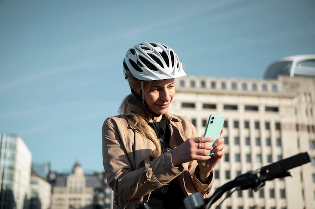 Woman checking her smartphone and sitting on her bike