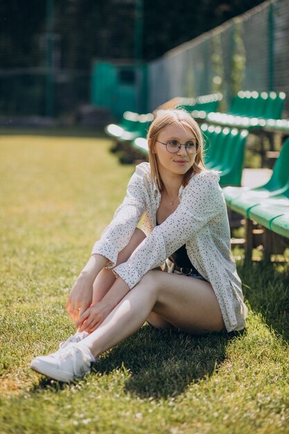 Woman cheerleader sitting at the football field