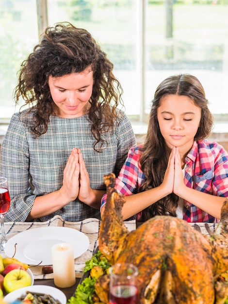 Woman and child praying at table