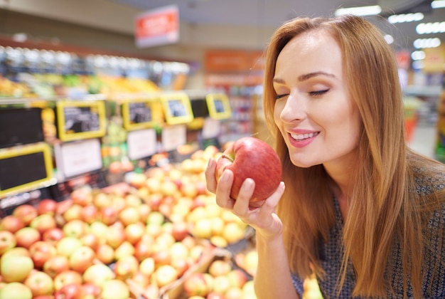 Free photo woman choosing apples from grocery store