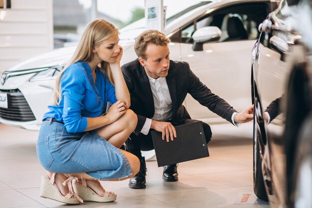 Woman choosing a car in a car showroom