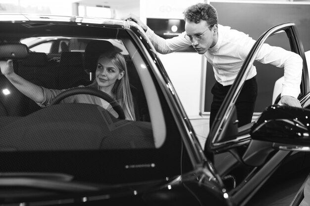 Woman choosing a car in a car showroom