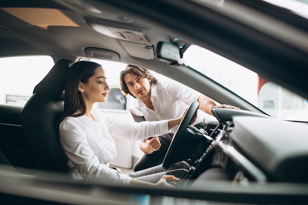 Woman choosing a car in a car showroom