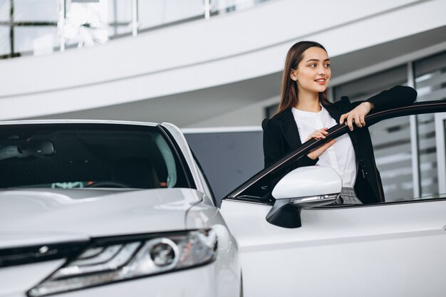 Woman choosing a car in a car showroom