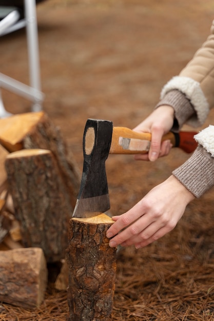 Free photo woman chopping wood with an axe for a bonfire