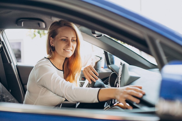 Free Photo woman chosing a car in a car showroom