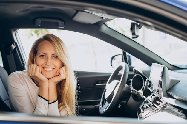 Free photo woman chosing a car in a car showroom