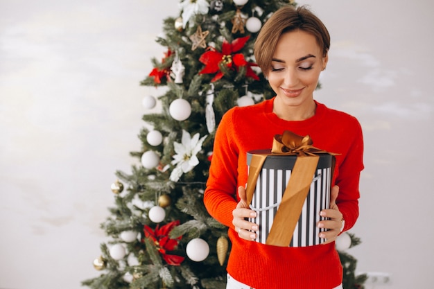 Woman on christmas with gifts by christmas tree