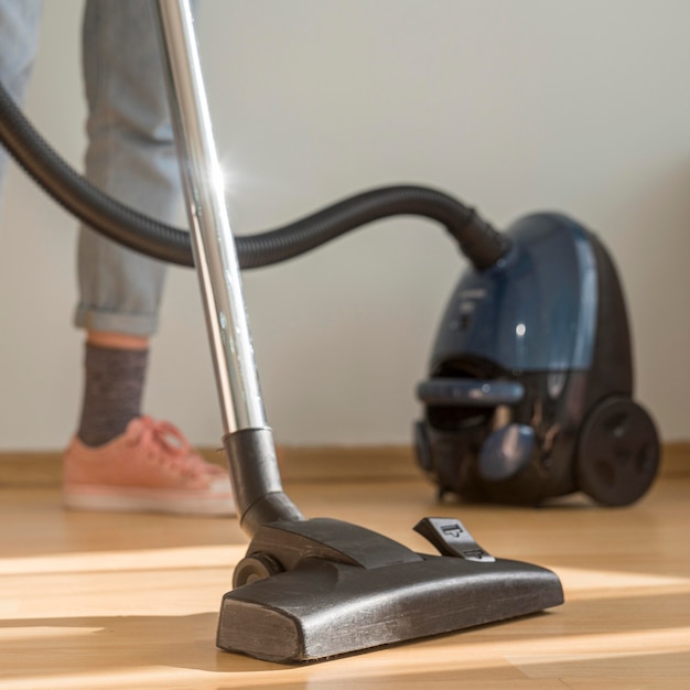 Free photo woman cleaning room with vacuum cleaner