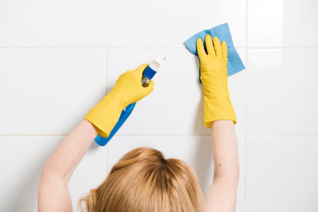 Woman cleaning the shower wall