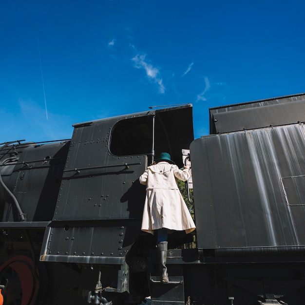 Free photo woman climbing on retro train