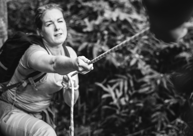 Woman climbing up a rope