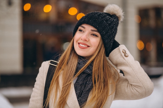 Woman in coat standing outside the cafe in a winter street