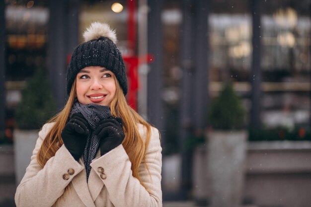 Woman in coat standing outside the cafe in a winter street