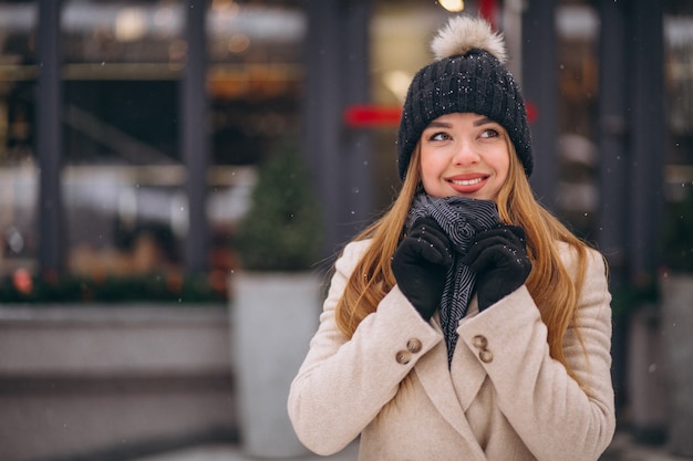 Woman in coat standing outside the cafe in a winter street