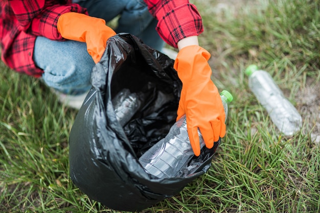 Free Photo woman collecting garbage in a black bag.