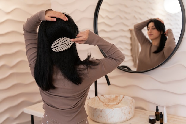 Free photo woman combing hair during her beauty routine