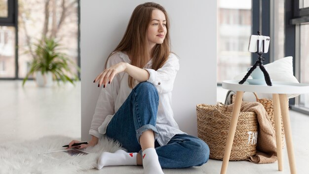 Woman coming up with new ideas for a blog on the floor