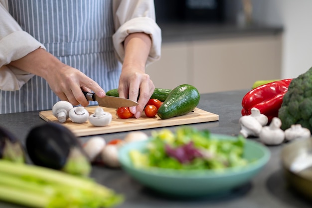 Woman cooking lunch and cutting vegetables