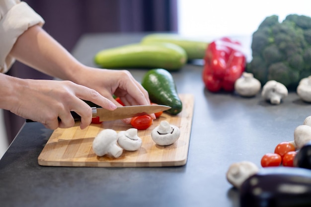 Free photo woman cooking lunch and cutting vegetables