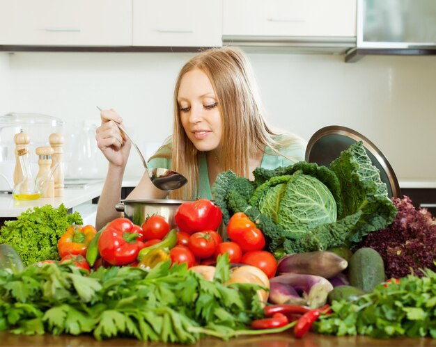 woman cooking with heap of raw vegetables