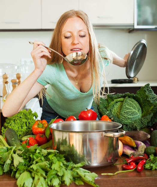 Free photo woman cooking with ladle from vegetables