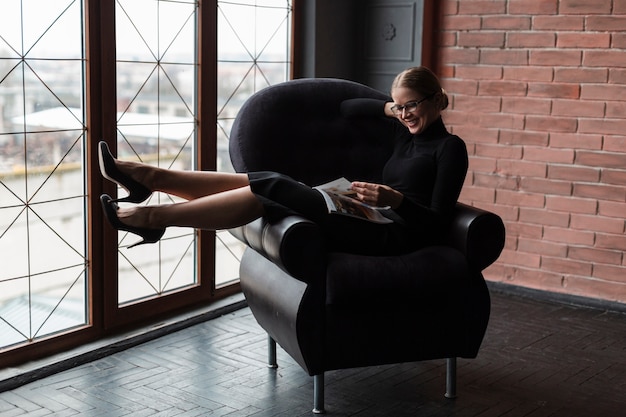 Free Photo woman on couch reading magazine